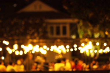 Restauranttaki bir çok insan gece mutlu mesut yemek yer ve eğlenir.