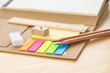 Not defterindeki kalem konsepti eğitim okulu ekipmanları ahşap masada.