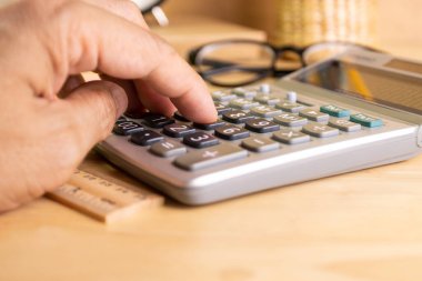 close up human finger push number button of calculator concept Calculation of income, expenditure, calculation