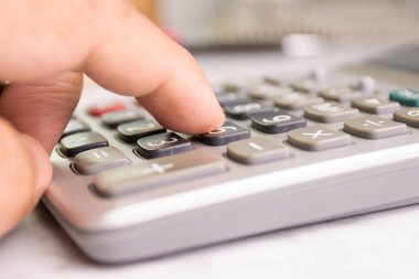 close up human finger push number button of calculator concept Calculation of income, expenditure, calculation