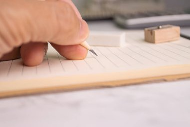 hand hold pencil write on paper note concept education or work job at office 