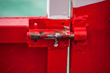 Kilitli eski kırmızı metal kapı. Kapalı giriş.