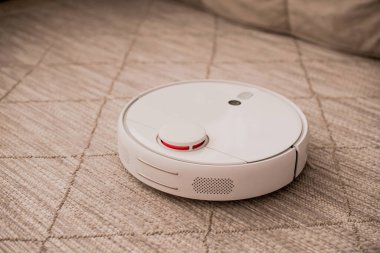 Beyaz robot süpürge iç döşemede.