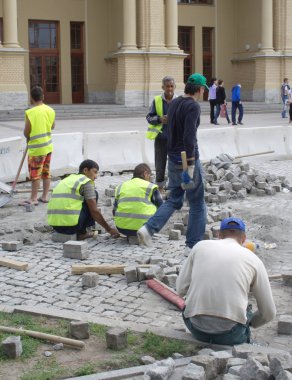 Orta Asya'dan gelen göçmen işçilerin döşemek bir cadde üzerinde Ağustos 05, 2012 yılında st