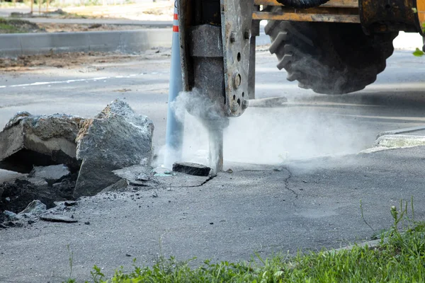 Yol tamiri. Eski bir asfalt katmanının hidrolik çekiçle çıkarılması. Asfaltın yeniden inşası