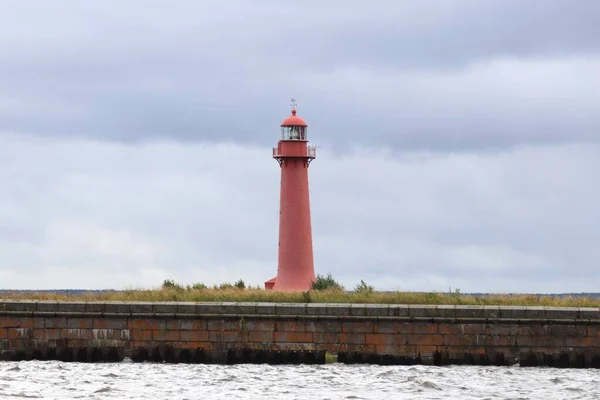 Koyda pembe bir deniz feneri Bulutlu bir havada.