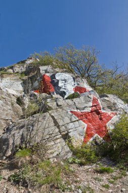 Portret van lenin en rode ster op een rots.
