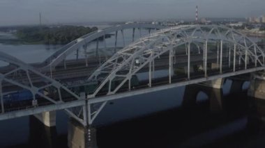 Dinyeper Nehri üzerindeki Darnitsky Köprüsü. Ukrayna şehri Kiev. Drone 'un videosu. Tren köprüden geçtiğinde, demiryolu köprüsünün kenarındaki açıklık.