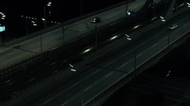 Darnitsky otomobil köprüsü. Kiev şehri. Ukrayna. Dinyeper Nehri 'nin karşısında. Drone 'un videosu. Köprüden çıkışların üst görüntüsü. İyi geceler. Sonlandırma. Trafik vardı.