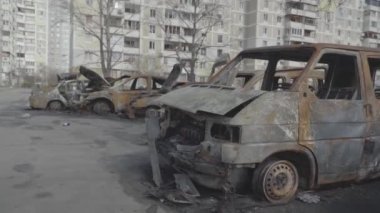 Şehir bombalandıktan sonra konut binalarının yakınındaki bir otoparkta yanmış arabalar. Ukrayna. Kyiv. İlçe Troieshchyna