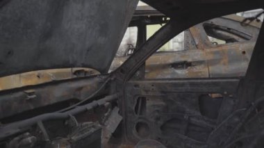 Şehir bombalandıktan sonra konut binalarının yakınındaki bir otoparkta yanmış arabalar. Ukrayna. Kyiv. İlçe Troieshchyna