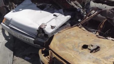 Rusya ile Ukrayna 'nın başkenti Kiev yakınlarındaki barışçıl bir şehirde yaşanan savaşın sonuçları. Sivillerin arabalarını tahrip etti. Araba mezarlığı. Havadan. Kıyametten sonra. Paslı arabalar. Irpin Şehri