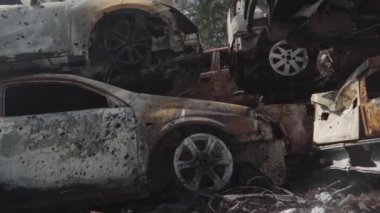 Consequences of the war with Russia in a peaceful city near Kiev, the capital of Ukraine. Destroyed cars of civilians. Cars cemetery. Aerial. Post-apocalypse. Rusty cars. Irpin city