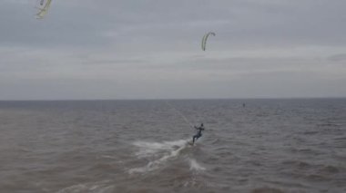 Atletler uçurtma sörfüne biner. Kiev Denizi. Yaz. Rüzgarlı bir hava. Rekabet. Renkli yelkenler. Havadan. Ukrayna. Kyiv.