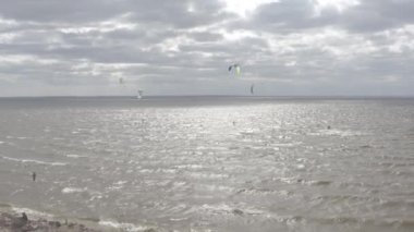 Atletler uçurtma sörfüne biner. Kiev Denizi. Yaz. Rüzgarlı bir hava. Rekabet. Renkli yelkenler. Havadan. Ukrayna. Kyiv.