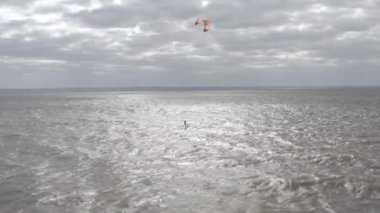 Atletler uçurtma sörfüne biner. Kiev Denizi. Yaz. Rüzgarlı bir hava. Rekabet. Renkli yelkenler. Havadan. Ukrayna. Kyiv.