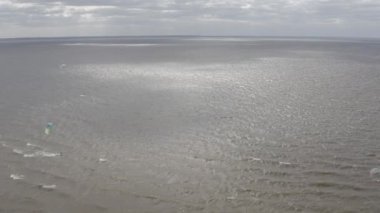 Atletler uçurtma sörfüne biner. Kiev Denizi. Yaz. Rüzgarlı bir hava. Rekabet. Renkli yelkenler. Havadan. Ukrayna. Kyiv.