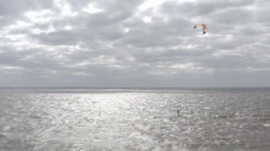 Atletler uçurtma sörfüne biner. Kiev Denizi. Yaz. Rüzgarlı bir hava. Rekabet. Renkli yelkenler. Havadan. Ukrayna. Kyiv.