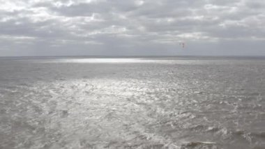 Atletler uçurtma sörfüne biner. Kiev Denizi. Yaz. Rüzgarlı bir hava. Rekabet. Renkli yelkenler. Havadan. Ukrayna. Kyiv.