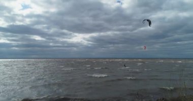 Atletler uçurtma sörfüne biner. Kiev Denizi. Yaz. Rüzgarlı bir hava. Rekabet. Renkli yelkenler. Havadan. Ukrayna. Kyiv.