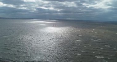 Atletler uçurtma sörfüne biner. Kiev Denizi. Yaz. Rüzgarlı bir hava. Rekabet. Renkli yelkenler. Havadan. Ukrayna. Kyiv.