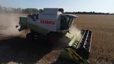 Buğday tarlasını hasat etmek için biçme makinesi. Buğday tarlasını hasat eden ekin biçme makinesini birleştirin. Hasattan sonra bir tarla. Havadan. Ukrayna. Kharkiv