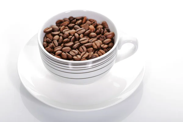 Una taza llena de granos de café — Foto de Stock