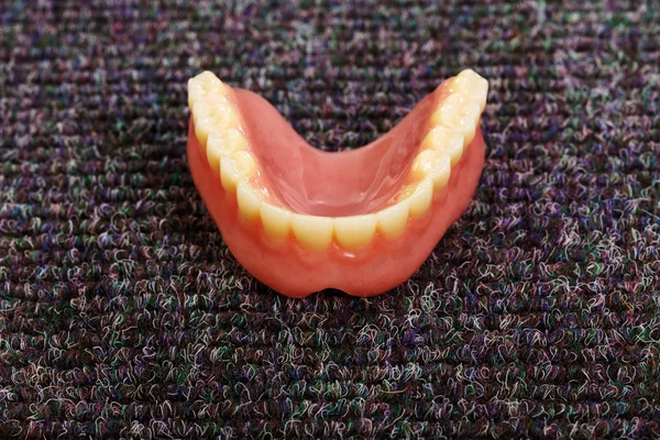 床に敷設の入れ歯のセット — ストック写真