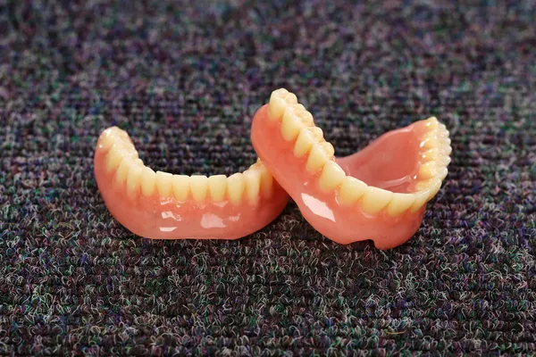 Um conjunto de dentaduras deitadas no chão — Fotografia de Stock