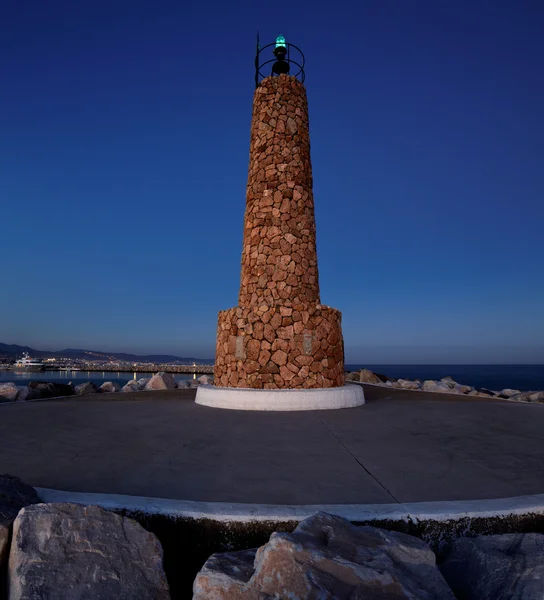 夜のスペイン、マルベージャのプエルト ・ バヌスで防波堤の端に灯台. — ストック写真