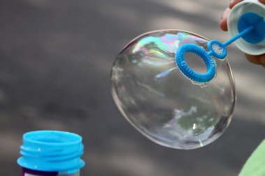 baloncuklar farklı kullanımlar için açık havada üfleyen çocuk