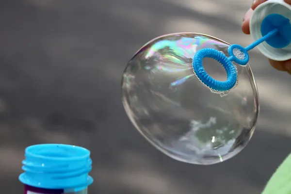 Ребенок выдувает пузырьки на открытом воздухе для различных целей — стоковое фото