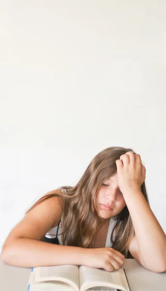 Gelangweilte Teenager-Mädchen lesen Hausaufgaben — Stockfoto