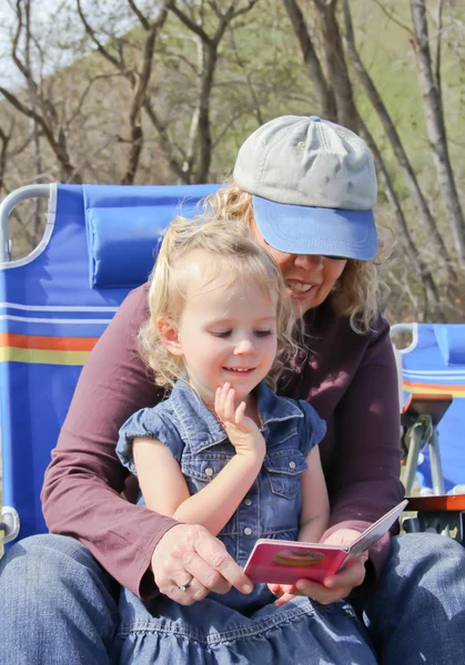 Grandma reading to toddler in park
