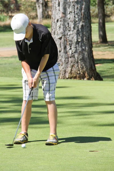 Giovane golfista di sesso maschile mettendo palla — Foto Stock