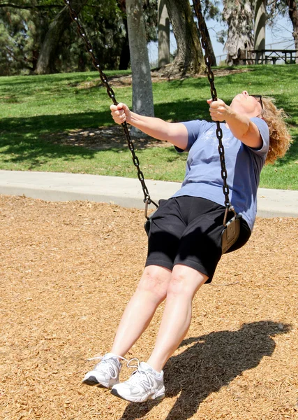 Mamie sur une balançoire dans le parc — Photo