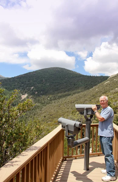 Senior med teleskop på berg — Stockfoto