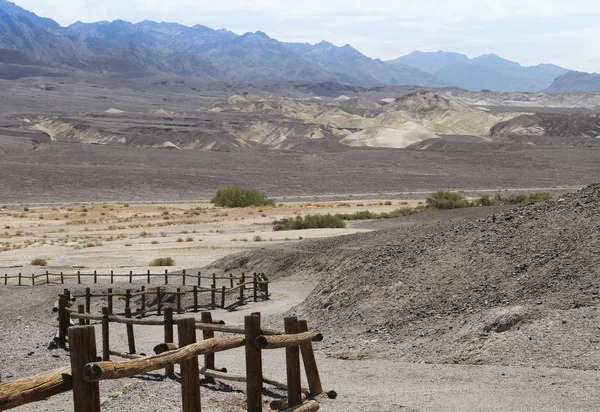 Kronkelende woestijn weg met log hek 2 — Stockfoto