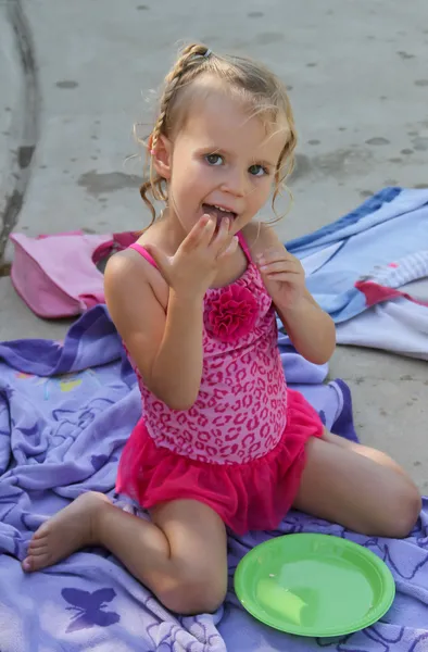 Glückliches weibliches Kleinkind isst am Pool — Stockfoto
