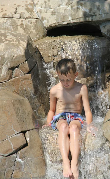 Meditating boy in waterfall — Stock Photo, Image