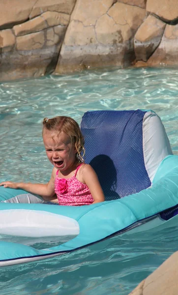 Crying toddler floating in pool — Stock Photo, Image
