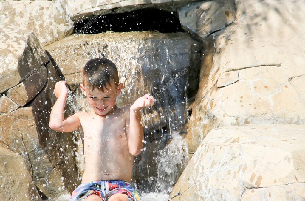 Happy Boy splashing in waterfall
