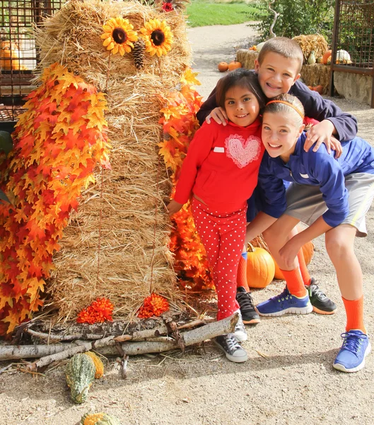 Kids with giant owl scarecrow — Stock Photo, Image