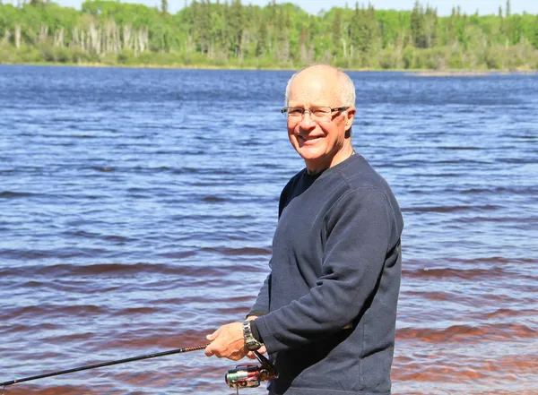 Retired Senior Male lake fishing — Stock Photo, Image