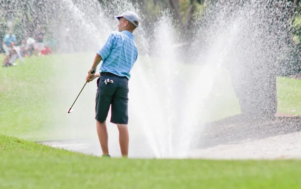 Teen golfer near billowing fountain — Stock Photo, Image