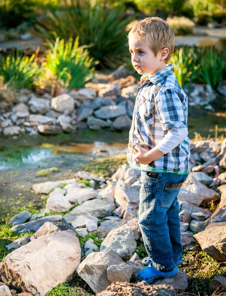 Pequeño niño rubio jugando en el jardín — Foto de Stock