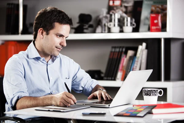 Young photographer at the studio doing some retouching — Stock Photo, Image