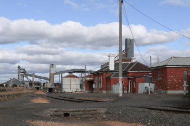 DUNOLLY, AUSTRALIA - 12 Haziran 2021: Dunolly tren istasyonundaki tren yolu, istasyon, silo ve diğer altyapı
