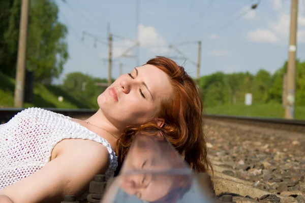 Krásná dívka ležící na kolejích — Stock fotografie