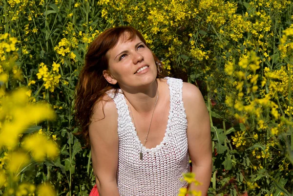 Menina bonita descansar no campo de colza — Fotografia de Stock